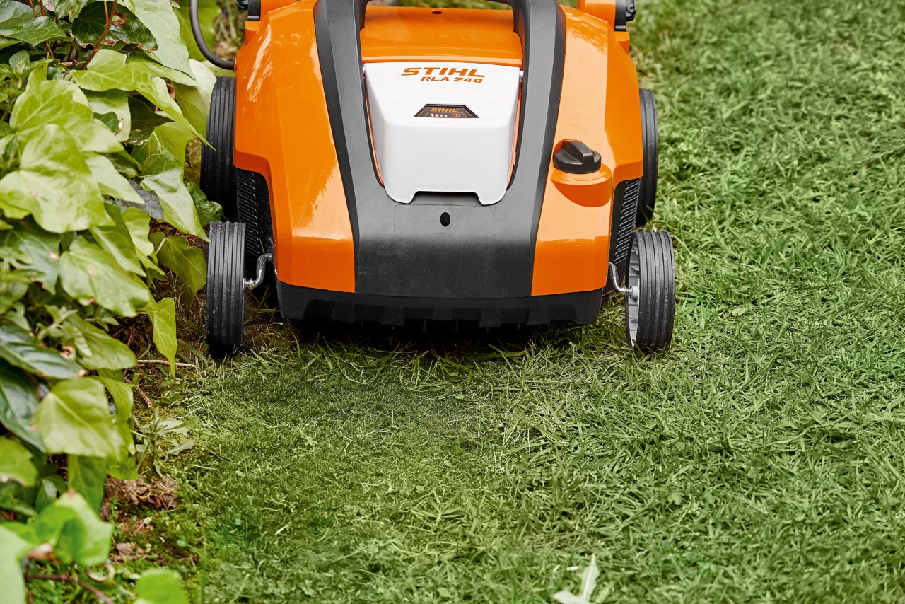 Közeli felvétel a STIHL RLA 240 akkumulátoros gyepszellőztetőről a gyep beszórása előtt homokkal