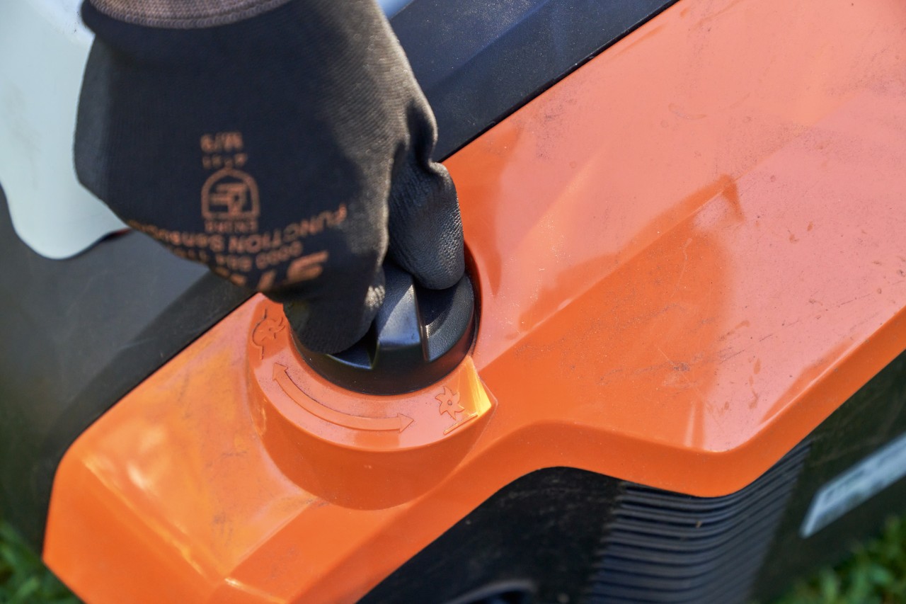 Közeli felvétel: STIHL FUNCTION SENSOTOUCH munkakesztyűt viselő kéz forgatja a STIHL RLA 240 akkumulátoros gyepszellőztető forgómarkolatát.
