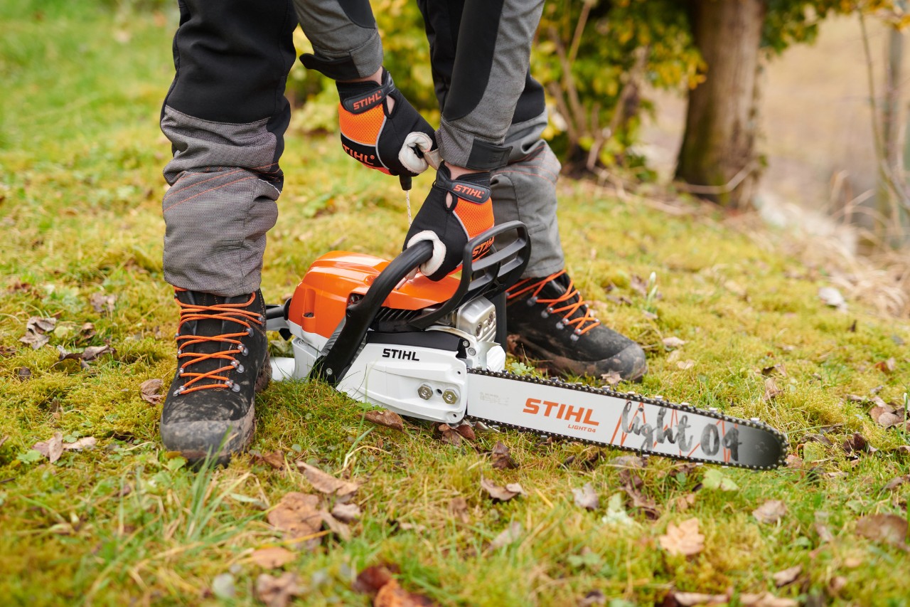 The STIHL MS261CM chainsaw, mit placed on the forest ground so that it could then be started safely by the person.