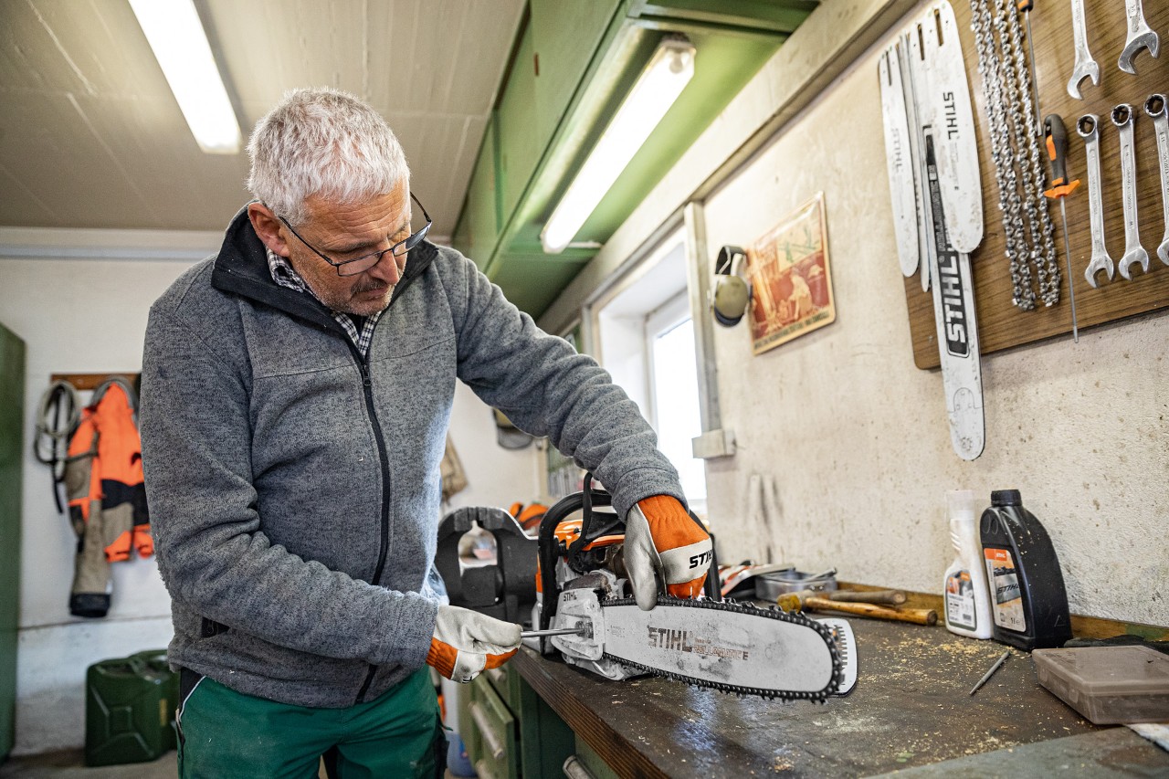 Egy férfi megfeszíti egy STIHL motorfűrész láncát