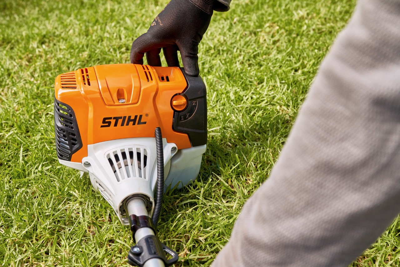 Egy férfi erősen a földre nyomja a STIHL FS 91 benzinmotoros kaszát