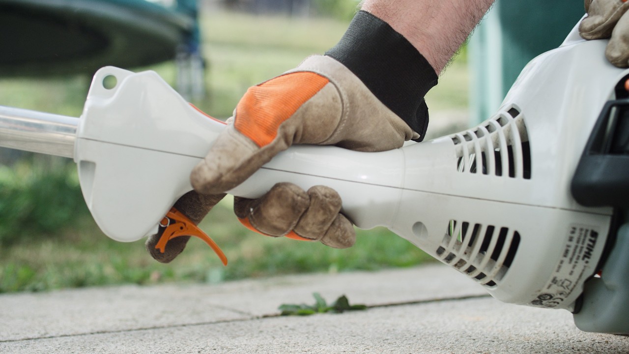 A STIHL FS 38 benzinmotoros kaszán megnyomják a gázemeltyűt