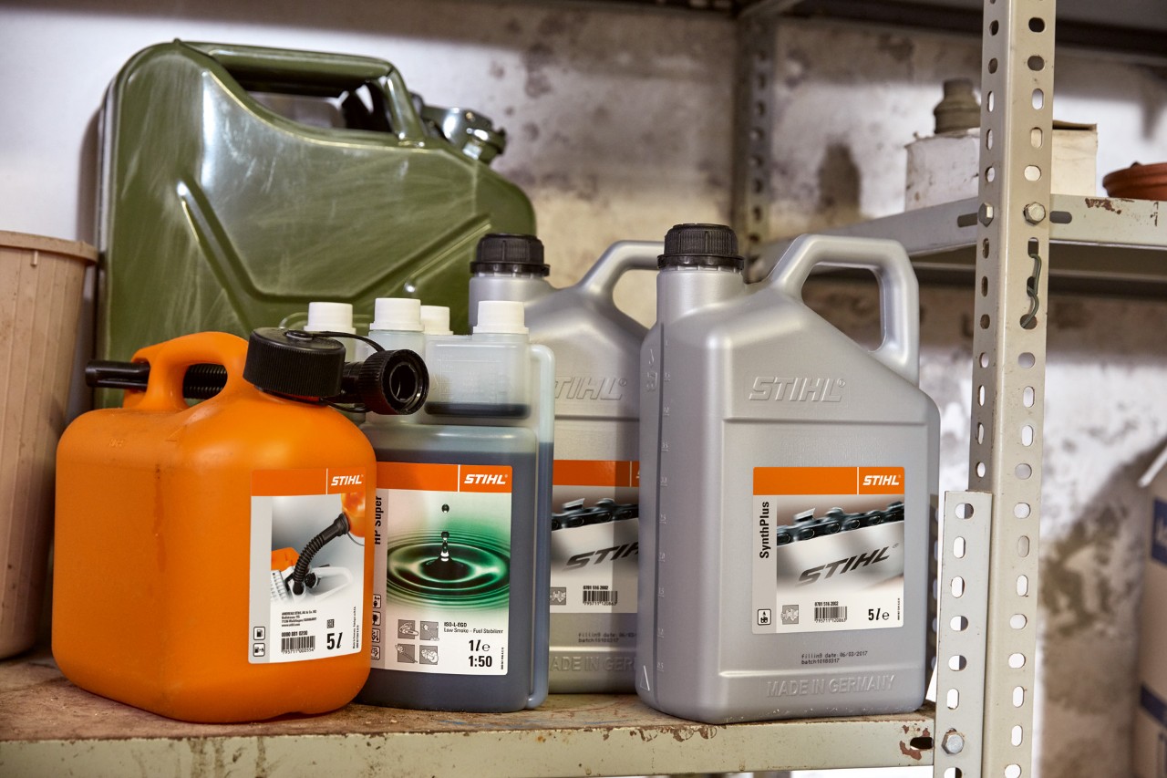 Világos kanna STIHL HP Super kétütemű motorolajjal és narancssárga kanna üzemanyag-keverékkel motoros kaszához