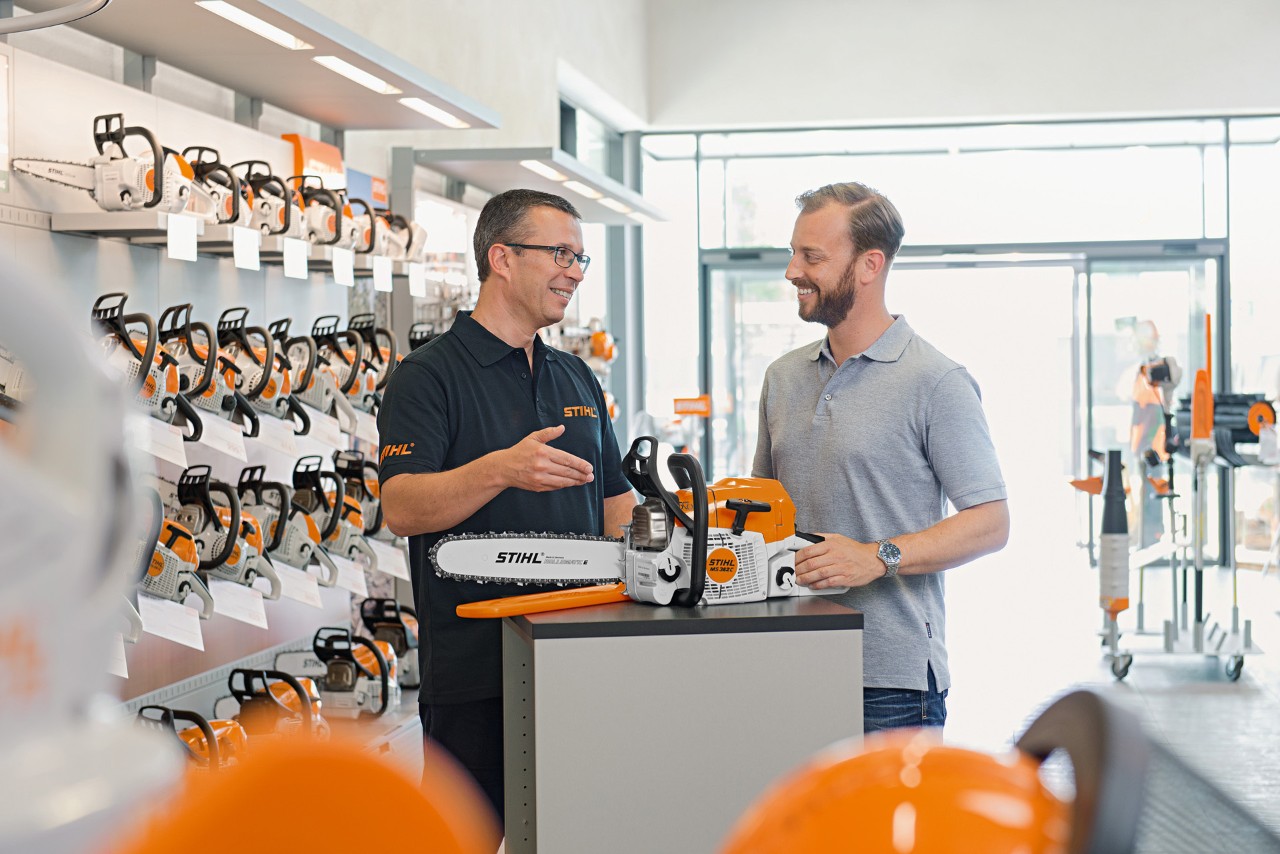 Egy STIHL szakkereskedő tanácsokat ad egy férfinak STIHL motorfűrész vásárlásakor