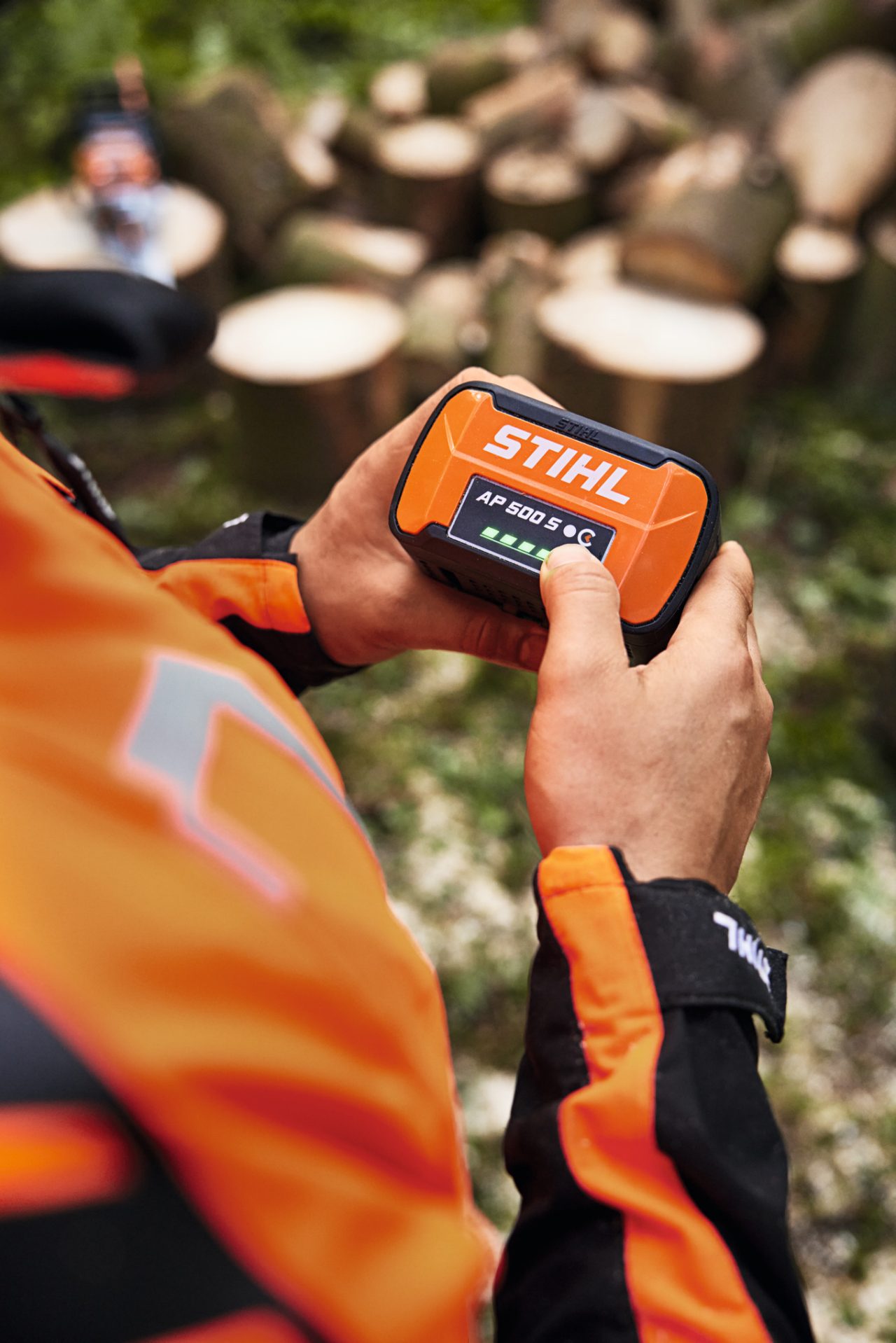 Közeli felvétel egy férfiről, aki STIHL AP 500 S lítiumion-akkumulátort tart a kezében