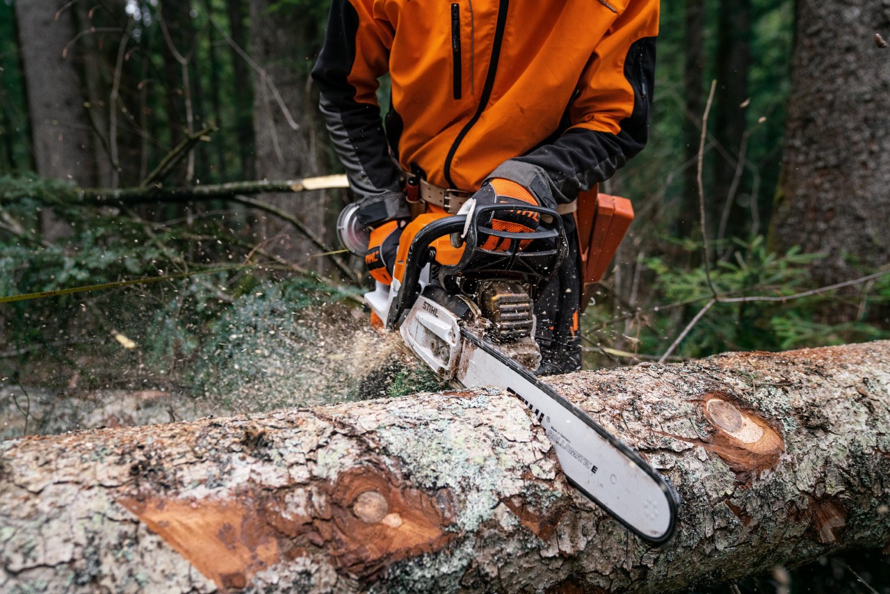 Magnéziumdugattyús MS 400 C-M STIHL benzines motorfűrésszel fát fűrészelnek a földön