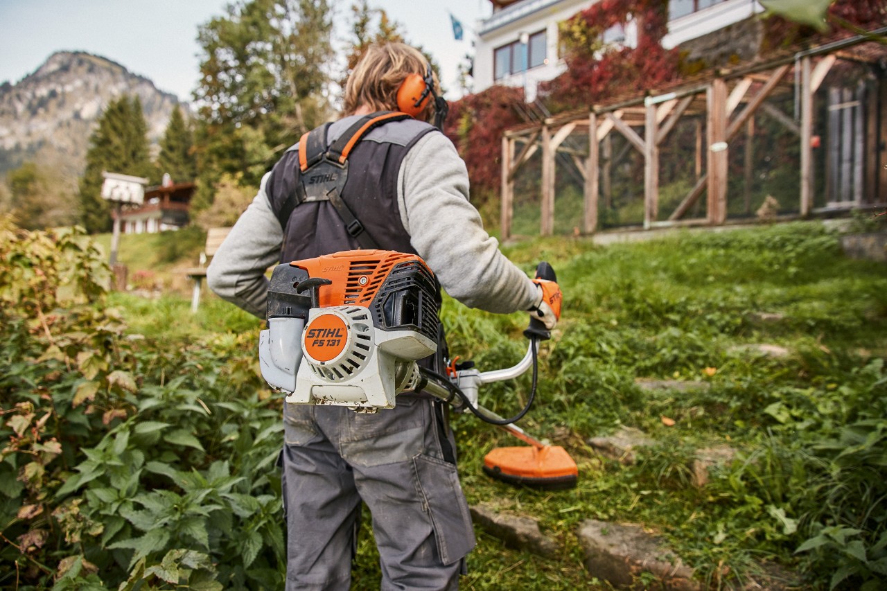 Egy ház előtti lejtős terepet a STIHL FS 131 4-Mix® benzinmotoros kaszával nyírnak